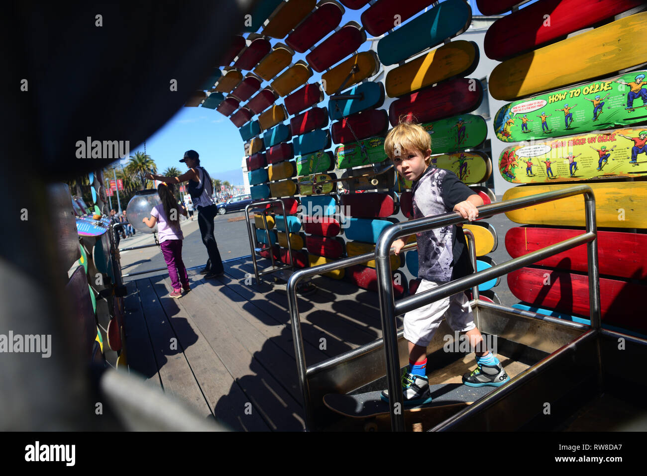 Young boy tries a skateboard game outside the Exploratorium, San Francisco. Stock Photo