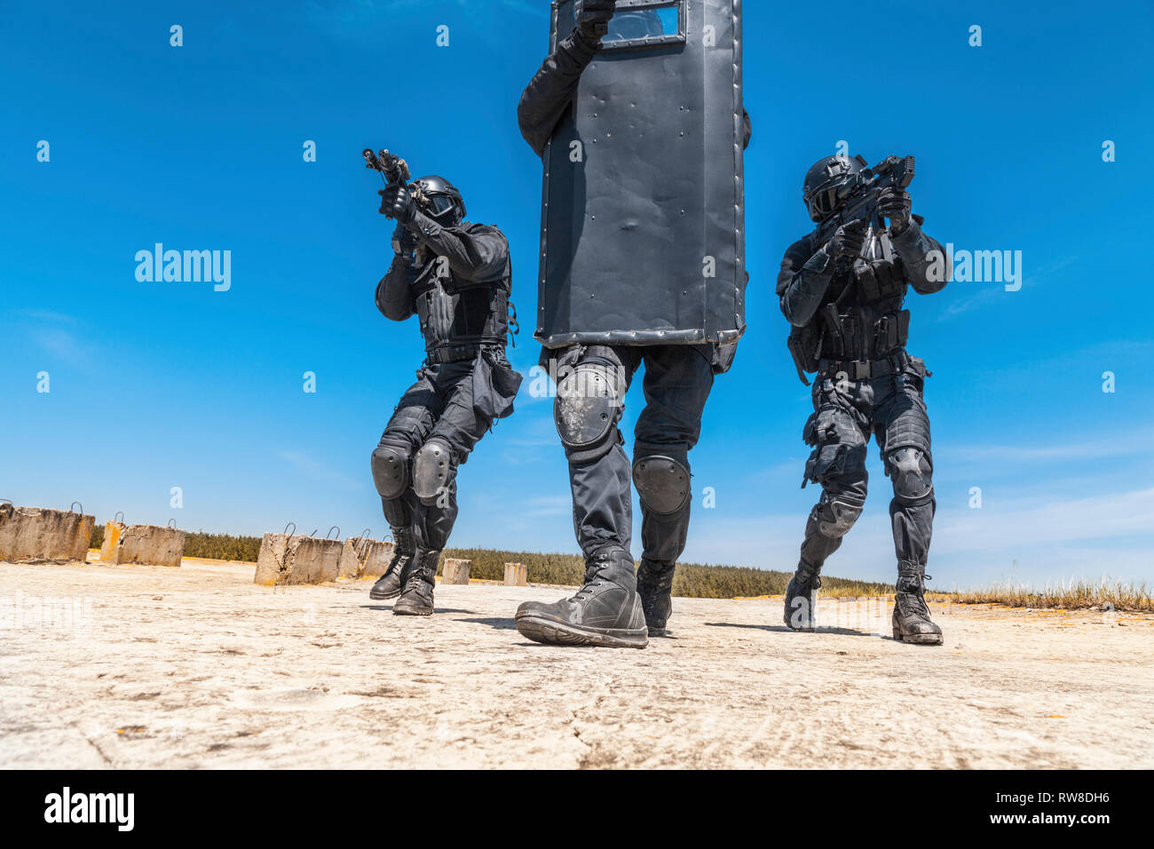 Studio shot of SWAT police special forces hiding behind ballistic