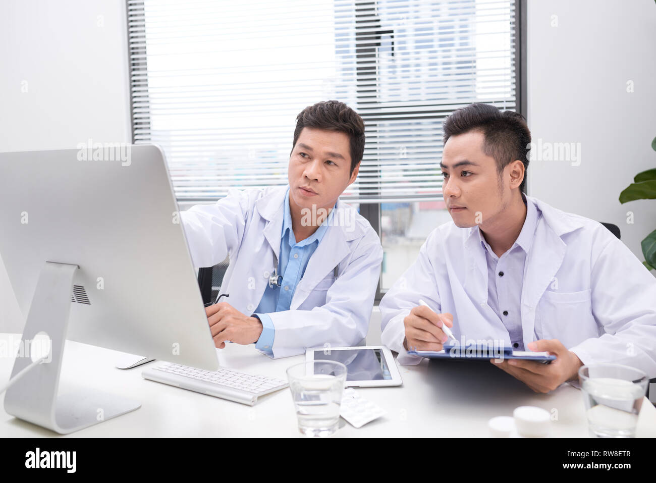 Hardworking doctors reviewing patient's file Stock Photo