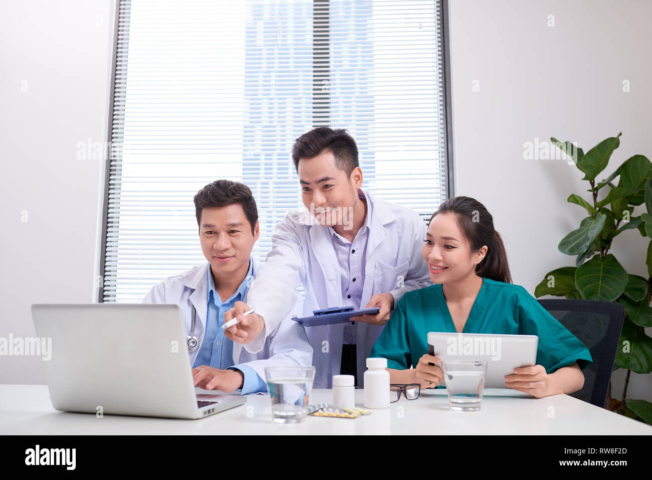 Group of doctors and nurses examining medical report of patient. Team ...