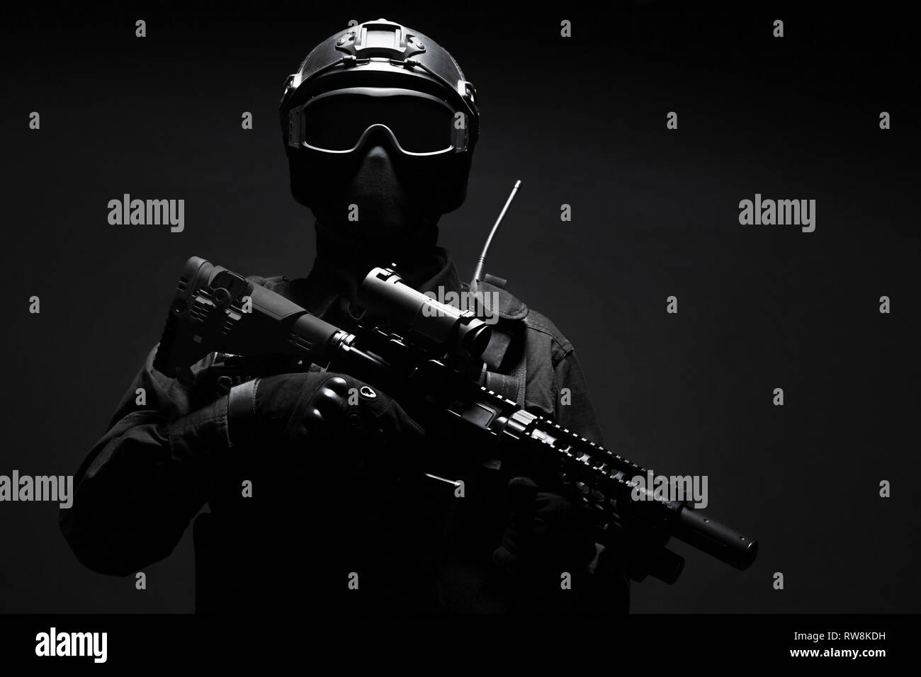 Spec ops police officer SWAT in black uniform and face mask, studio ...