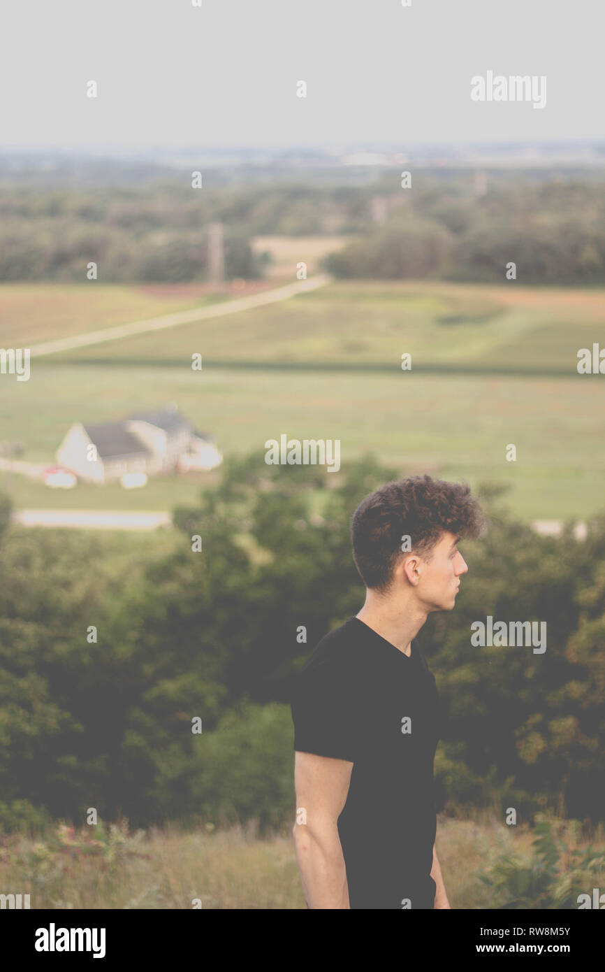 Man looking off in distance on hillside Stock Photo