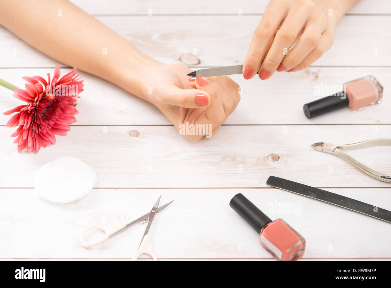 Woman Hand Care. Closeup Of Beautiful Female Hands Having Spa Manicure At Beauty Salon. Beautician Filing Clients Healthy Natural Nails With Nail File Stock Photo