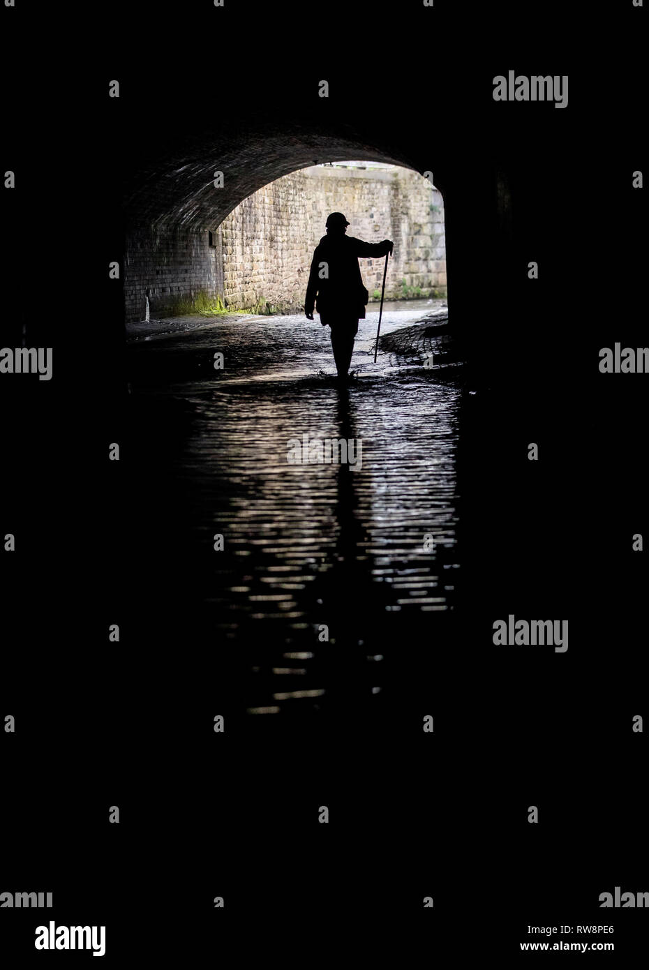 A man urban caving as an underground network of rivers are opened up to the public for an audio-visual spectacular during the Sheffield Adventure Film Festival. Stock Photo