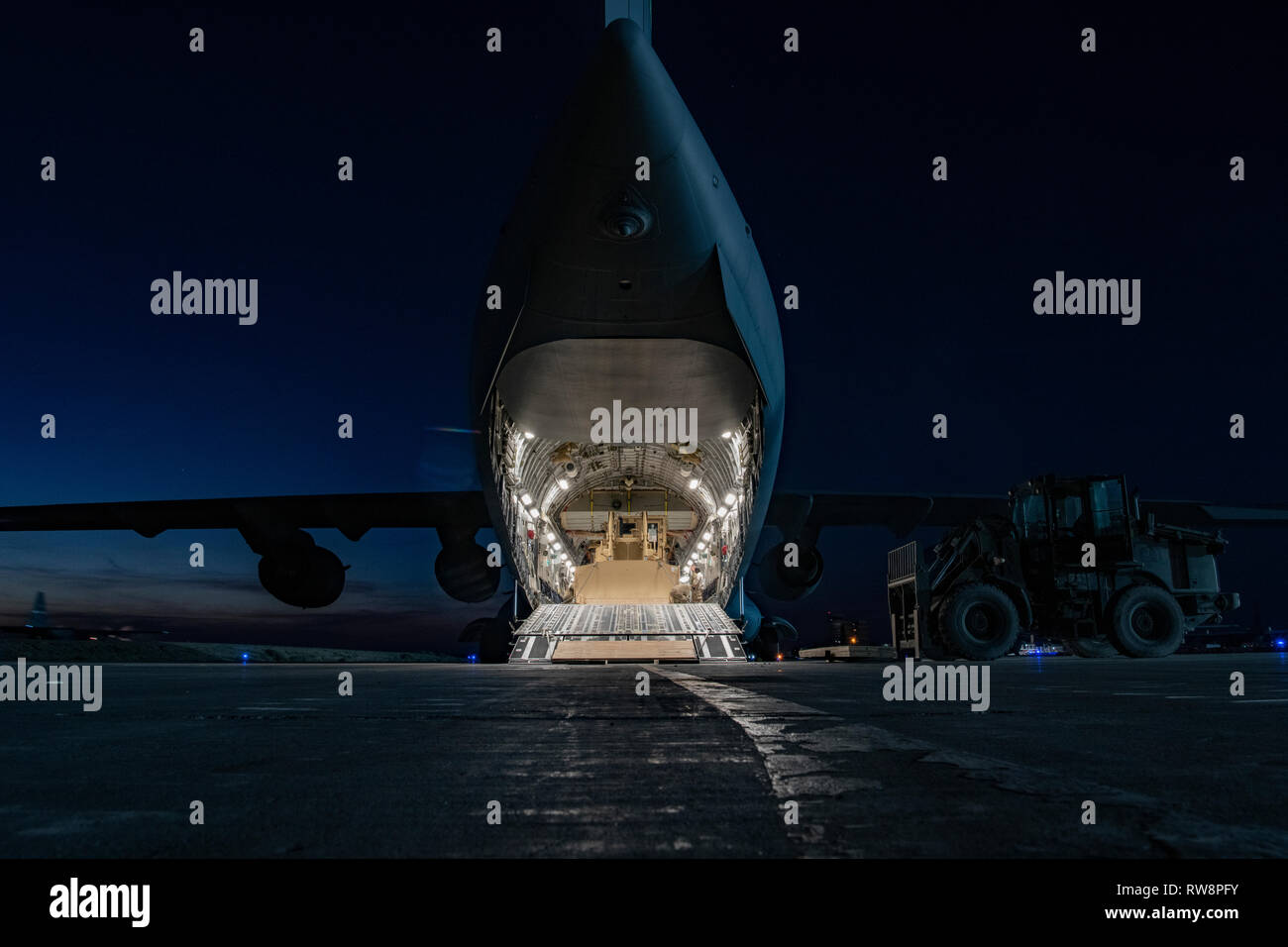 A C-17 Globemaster III loaded with a D7R-II medium bulldozer sits prepared for forward deployment at an undisclosed location in Southwest Asia, Jan. 11, 2019. The 386th Air Expeditionary Wing oversees the busiest aerial port of debarkation in the U.S. Air Forces Central Command area of responsibility in support of Operations Inherent Resolve and Freedom’s Sentinel. (U.S. Air Force Photo/Tech. Sgt. Robert Cloys) Stock Photo