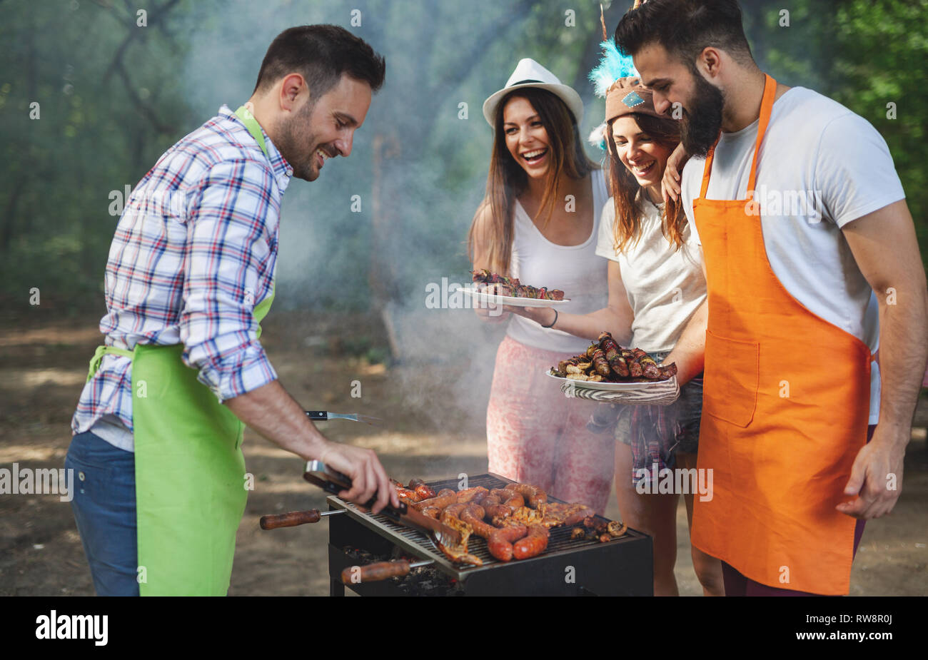 Group of friends having a barbecue and grill party in nature Stock