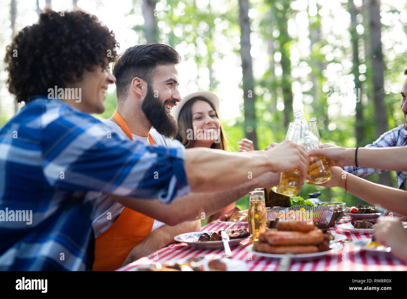 Group of happy friends having a barbecue party in nature Stock Photo ...
