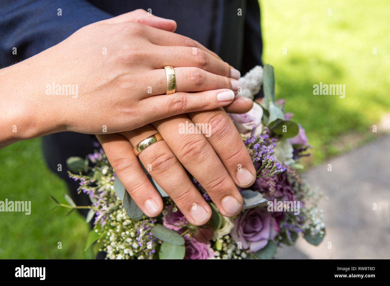 Hands of bride and groom with flower bouquet and wedding rings Stock ...