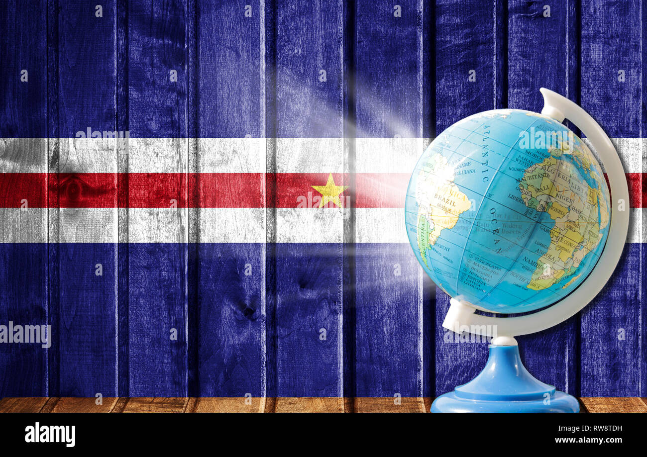 Globe with a world map on a wooden background with the image of the flag of Cape verde. The concept of travel and leisure abroad. Stock Photo