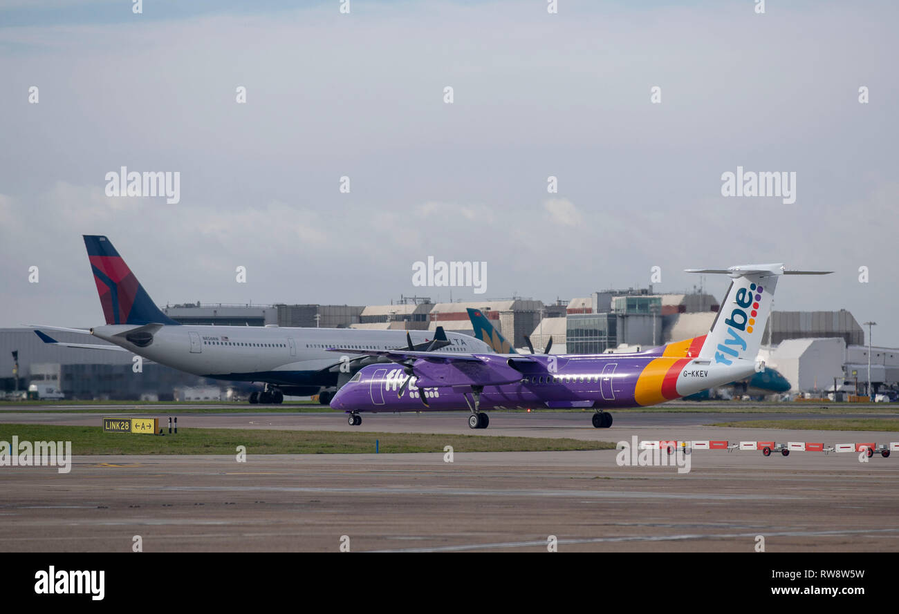 A flybe Bombardier Dash 8 Q400 plane taxis to the southern runway at Heathrow Airport in West London Stock Photo