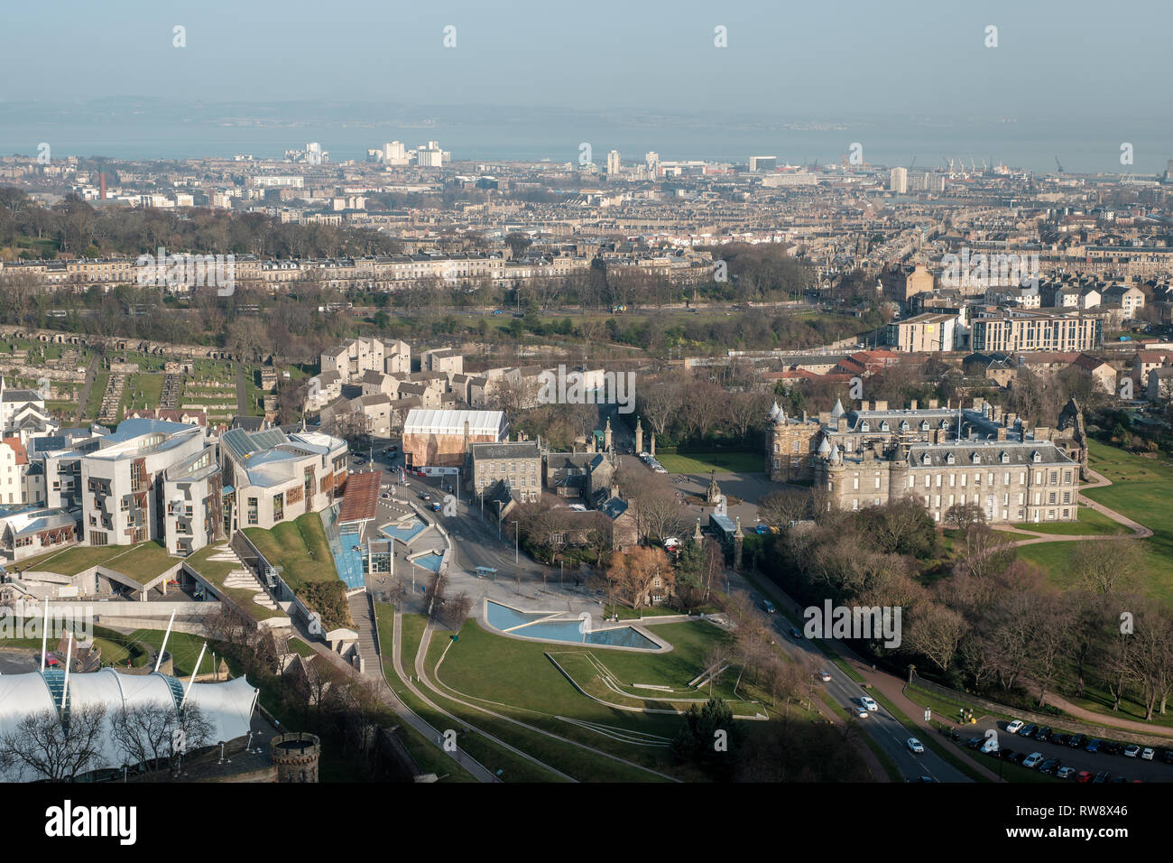 View from Salisbury Crags of the Palace of Holyroodhouse and the Scottish National Parliament building on a sunny day, Edinburgh, Scotland Stock Photo