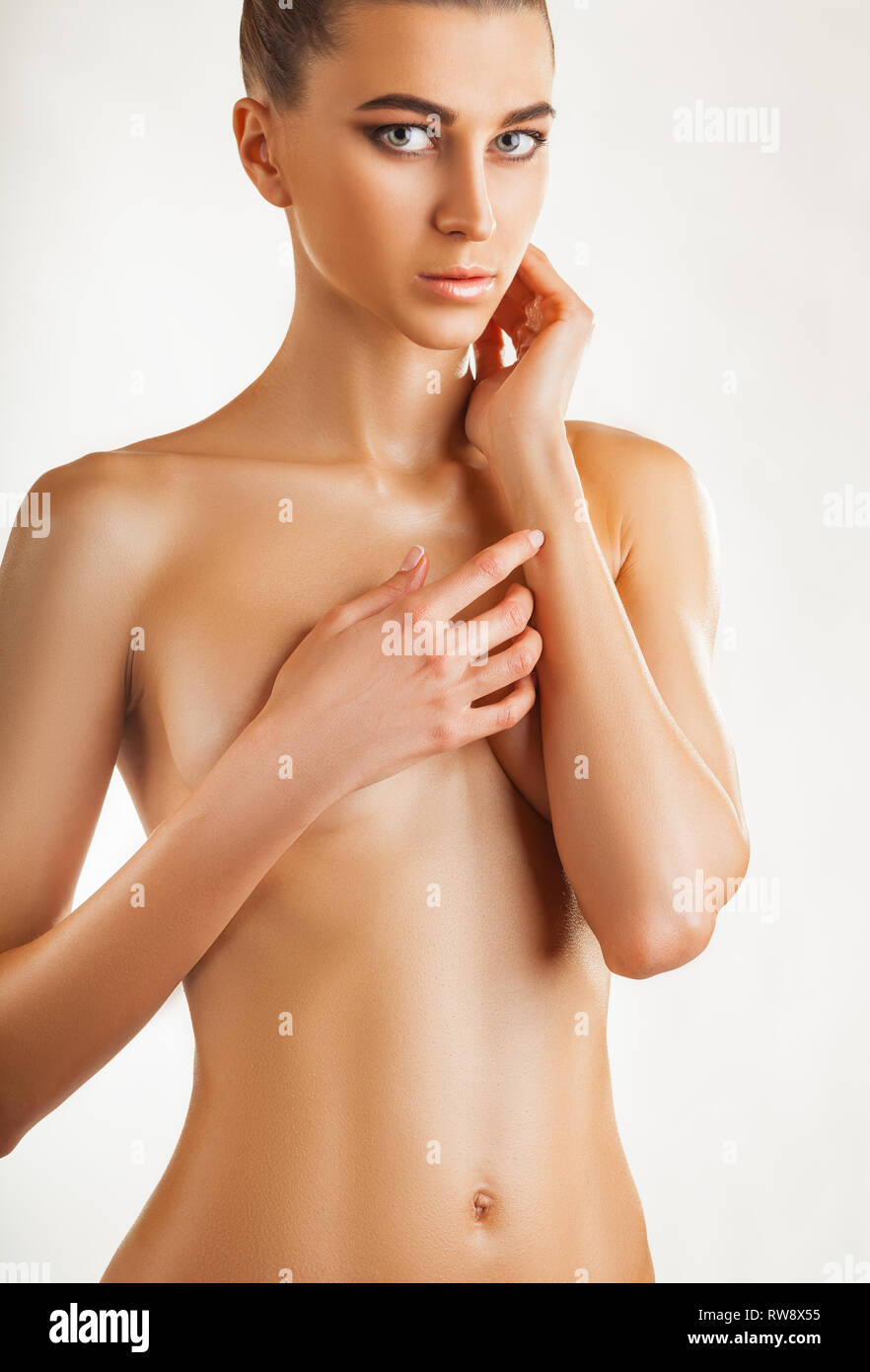 Beautiful young slim woman covers her bare breasts. Isolated on white  background Stock Photo - Alamy