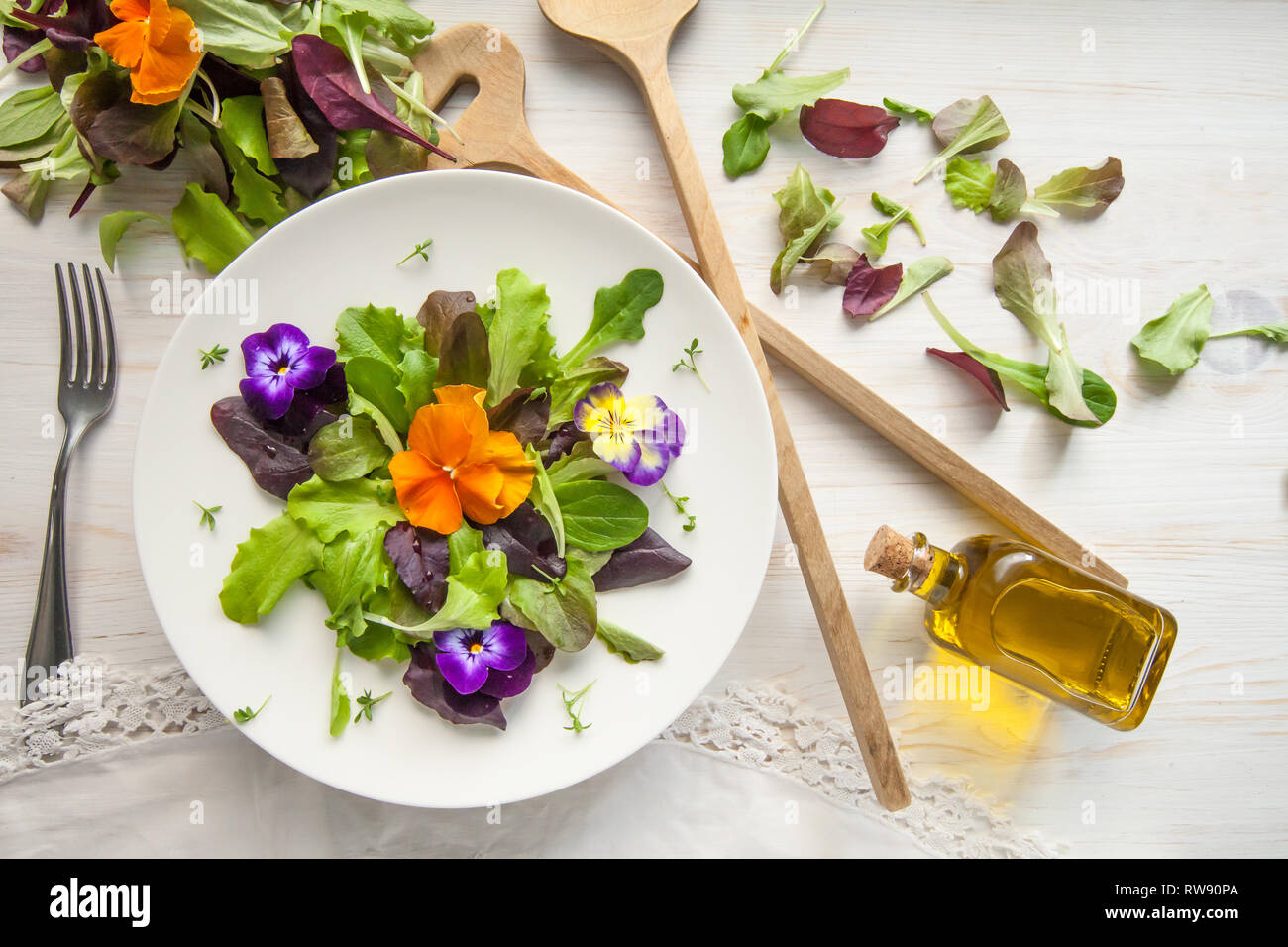 Lettuce and flower salad on woody white background spring, easter Stock
