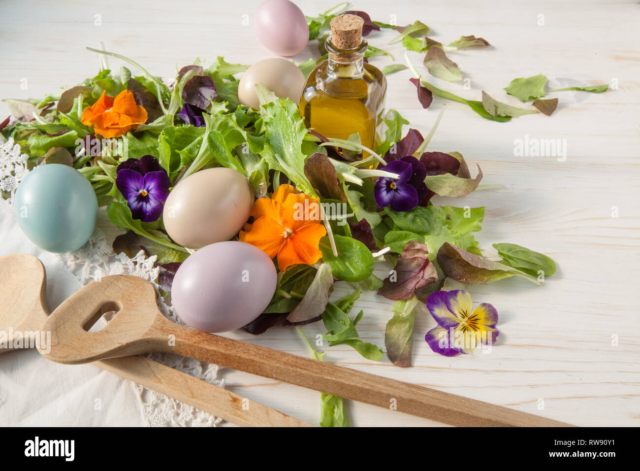 Lettuce and flower salad on woody white background spring, easter Stock