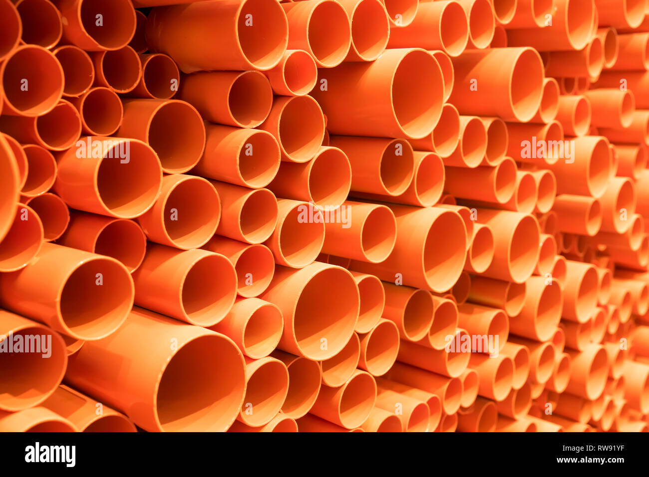 orange PVC pipes stacked in construction site Stock Photo Alamy
