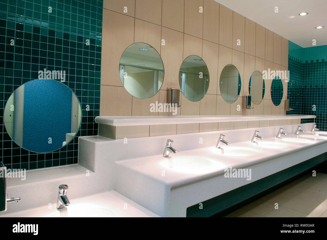 Rows of sinks and mirrors in a public restroom Stock Photo