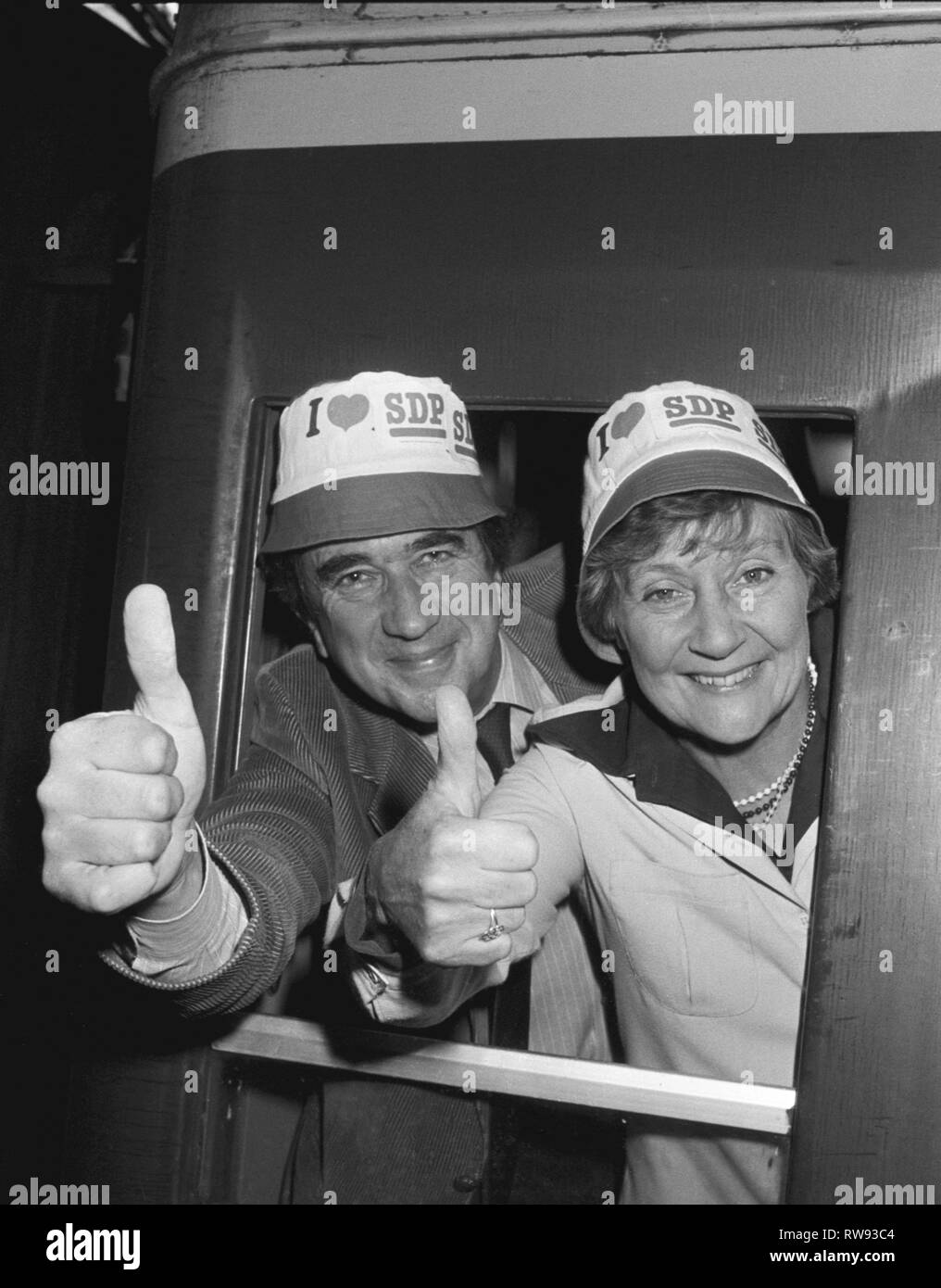 Social Democratic Party leaders Shirley Williams and Bill Rodgers wearing 'I love the SDP' hats aboard their train at Paddington Station bound for Torquay and their annual party conference. Stock Photo