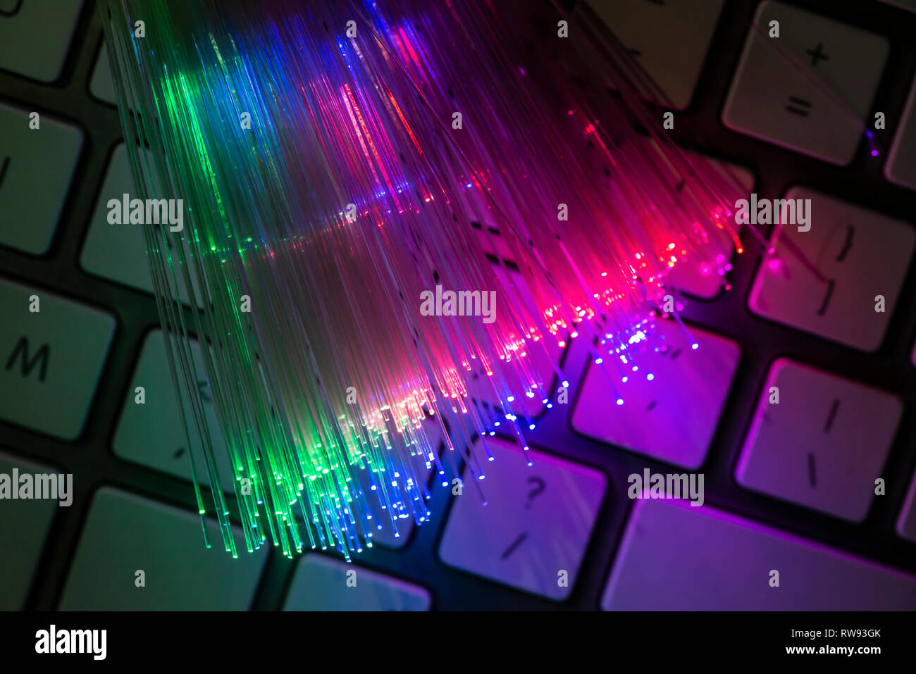 Colourful optic fibers illuminated on keyboard. High speed internet concept. Data transfer optic fiber cable. Bunch of many optical fibers, glowing di Stock Photo