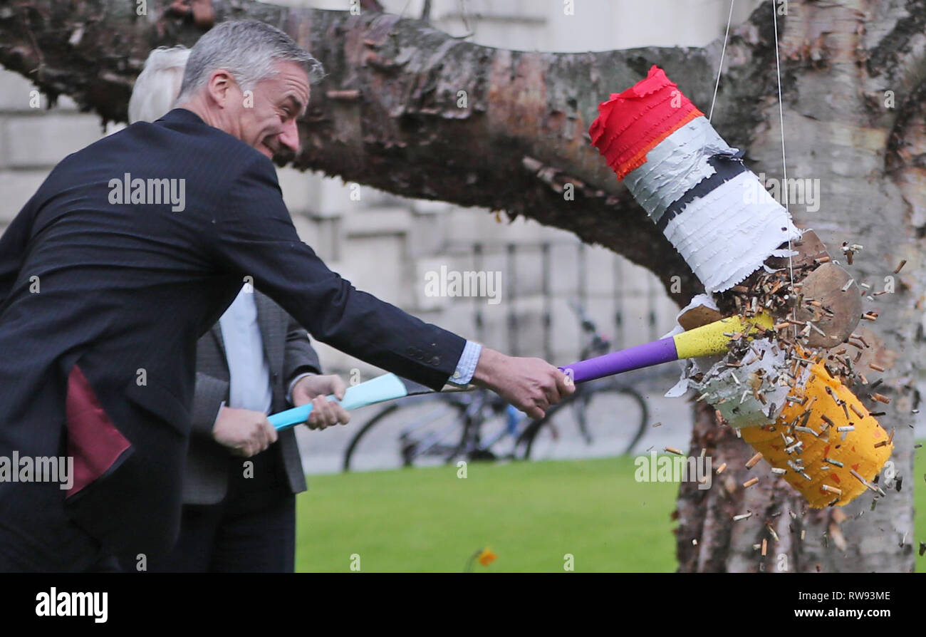 The Provost of Trinity College Dr Patrick Prendergast and Junior Minister for Health Catherine Byrne smash a pinata full of cigarette butts as they launches the campaign for a tobacco free campus for National No Smoking Day. Stock Photo