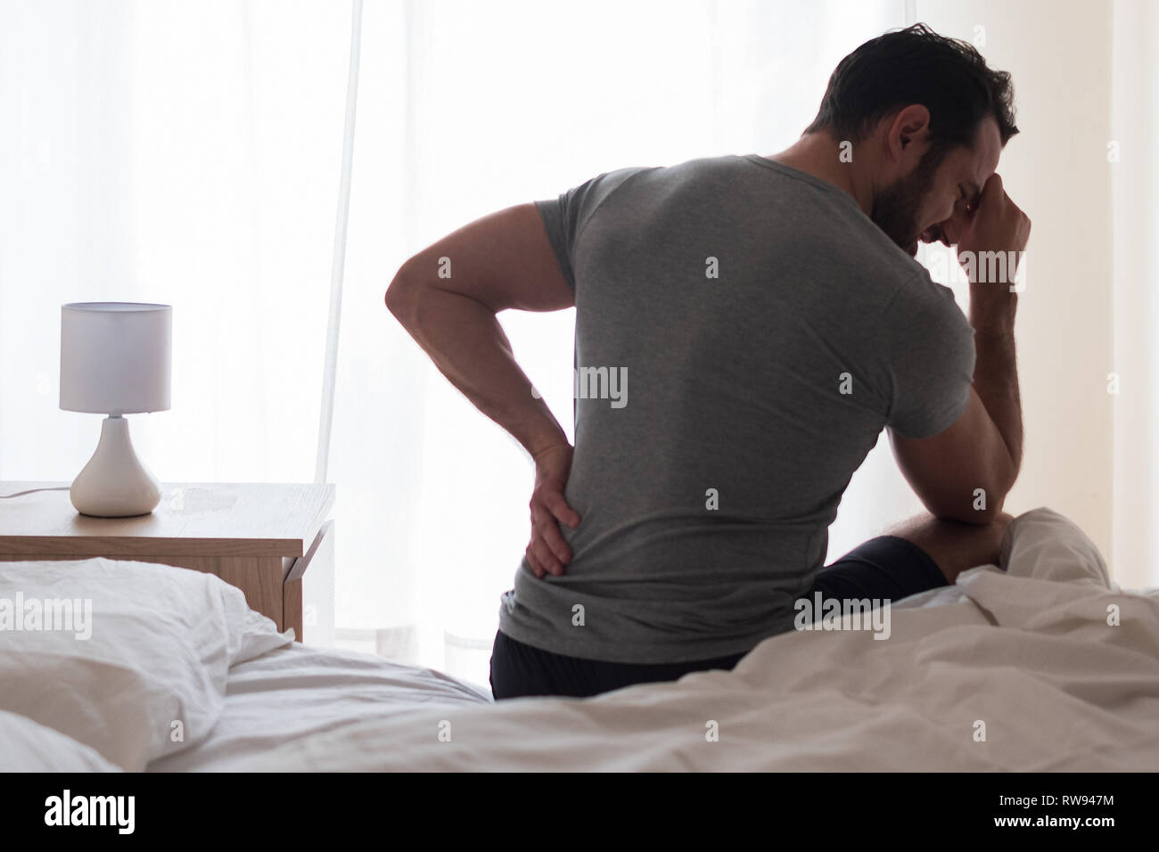 Man feeling backache after sleeping in bed Stock Photo Alamy