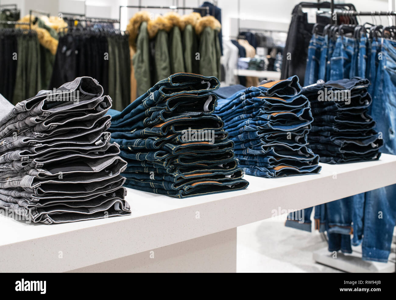 Blouses and jeans on shelf in fashion clothing store. Casual clothes in  shop. Commercial and fashion concept Stock Photo - Alamy