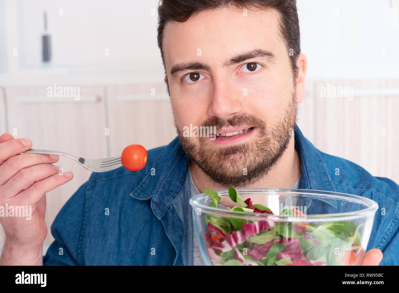 Man in the kitchen ready to eat vegetables Stock Photo - Alamy