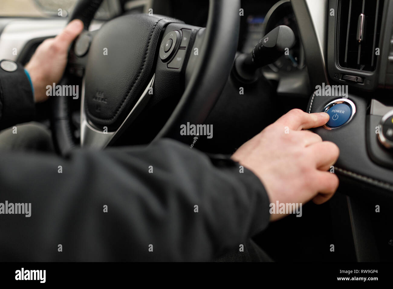 driver pushing car engine start-stop button in modern car. Stock Photo