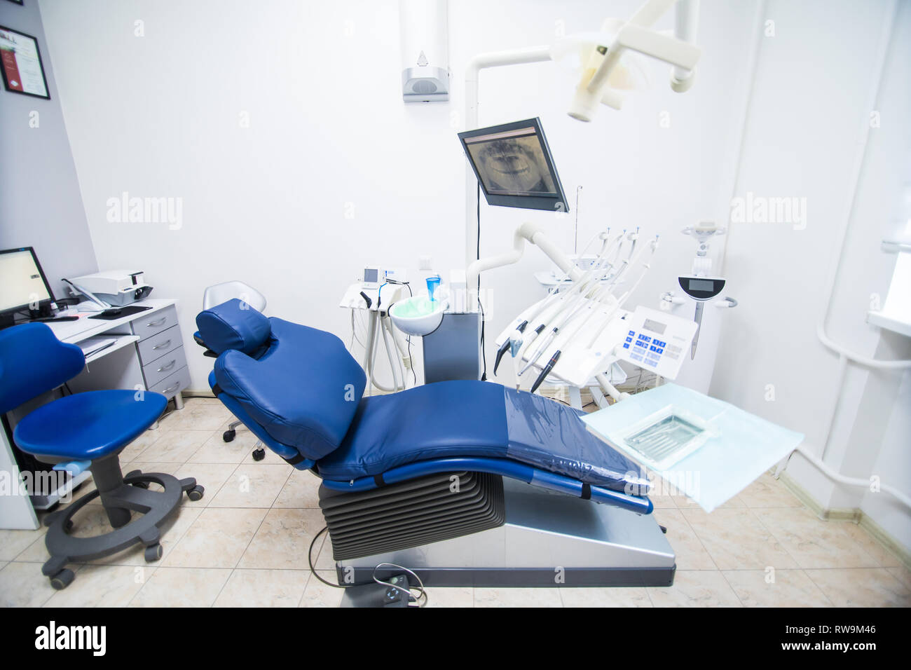 Modern dental practice. Dental chair and other accessories used by dentists in blue Stock Photo
