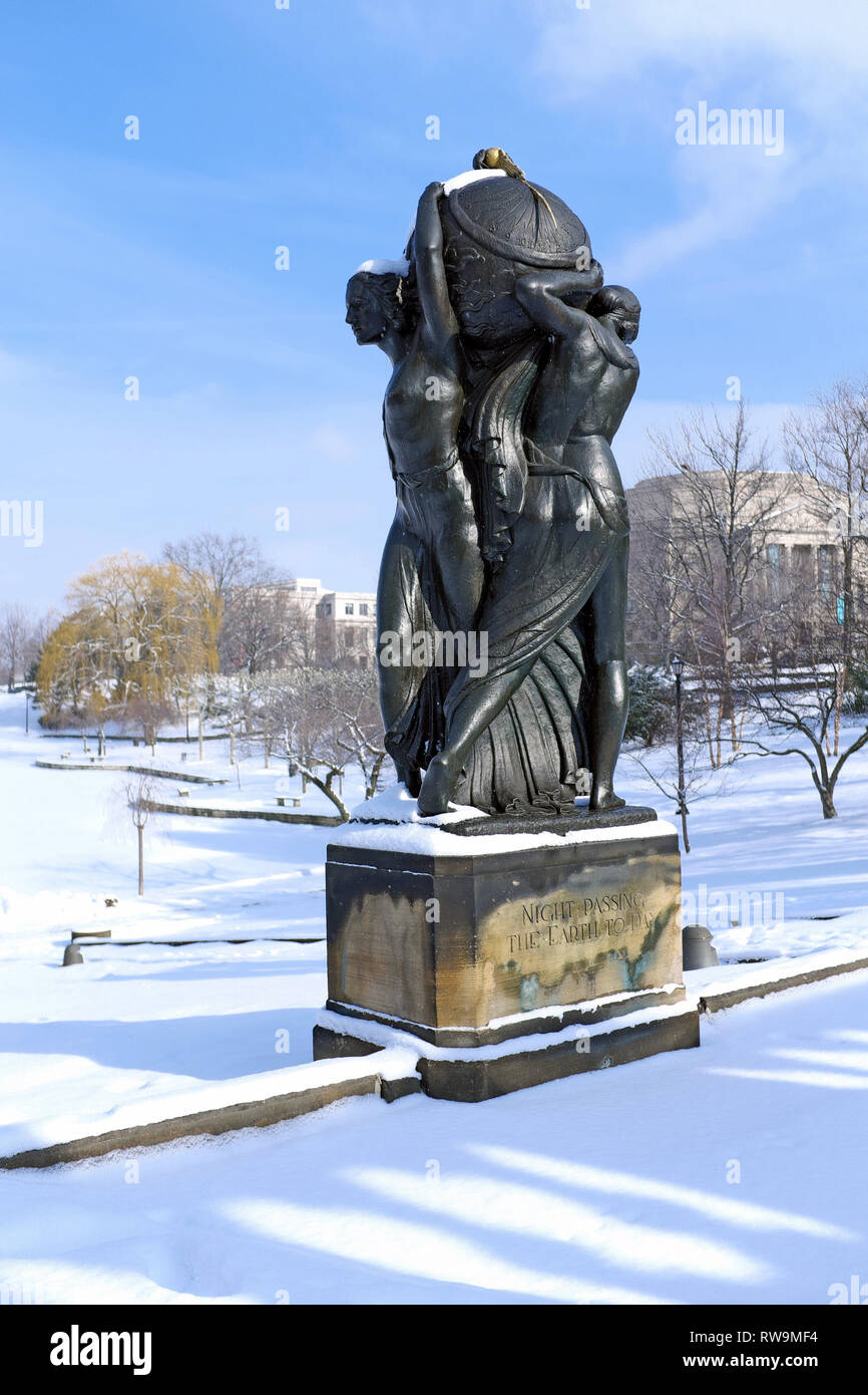 Overlooking Wade Lagoon in a snowy winter landscape is the outdoor sculpture by Frank Jirouch, Night Passing Earth to Day in Cleveland, Ohio, USA. Stock Photo
