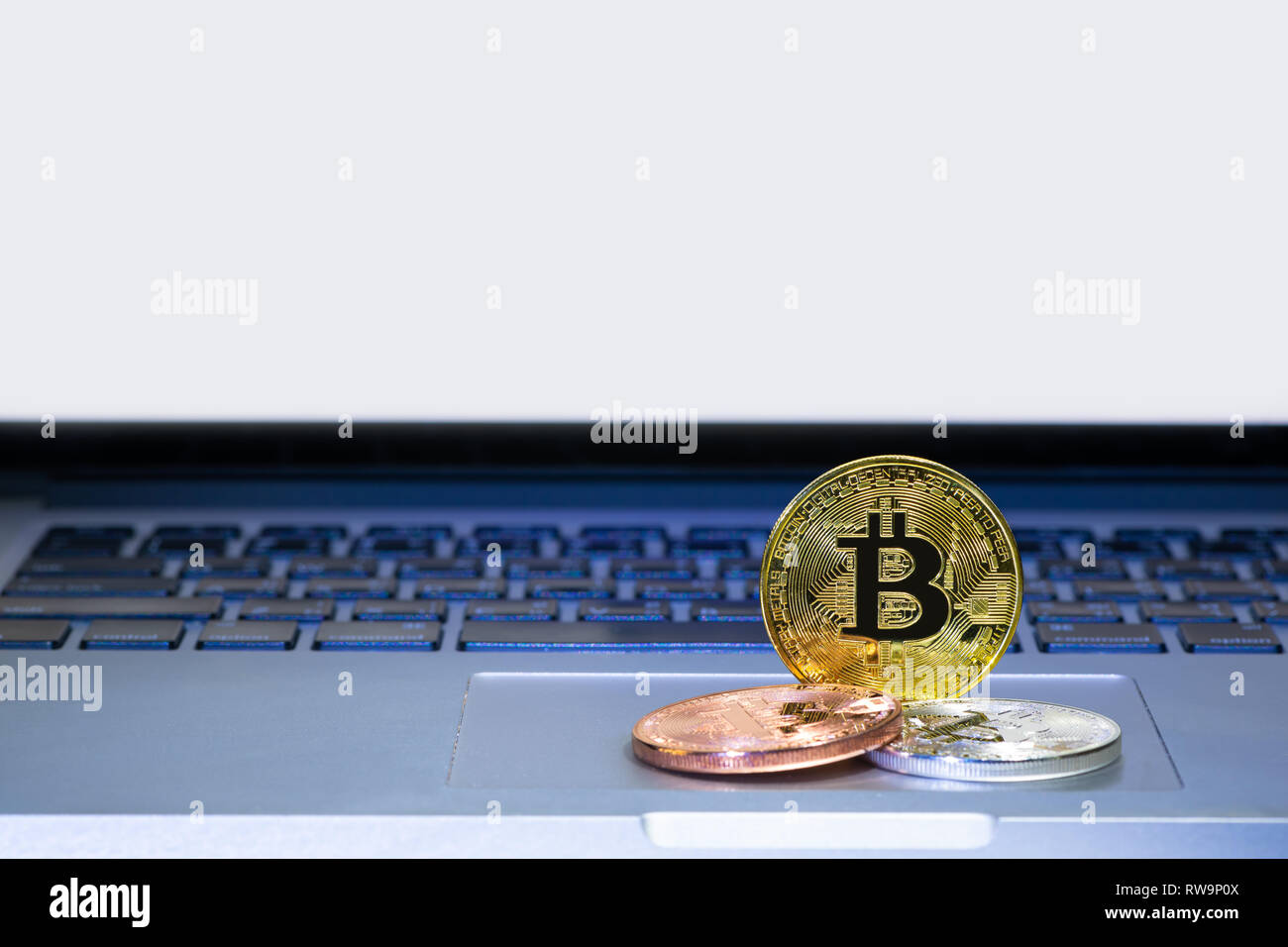 Bitcoin coins on laptop computer track pad Stock Photo