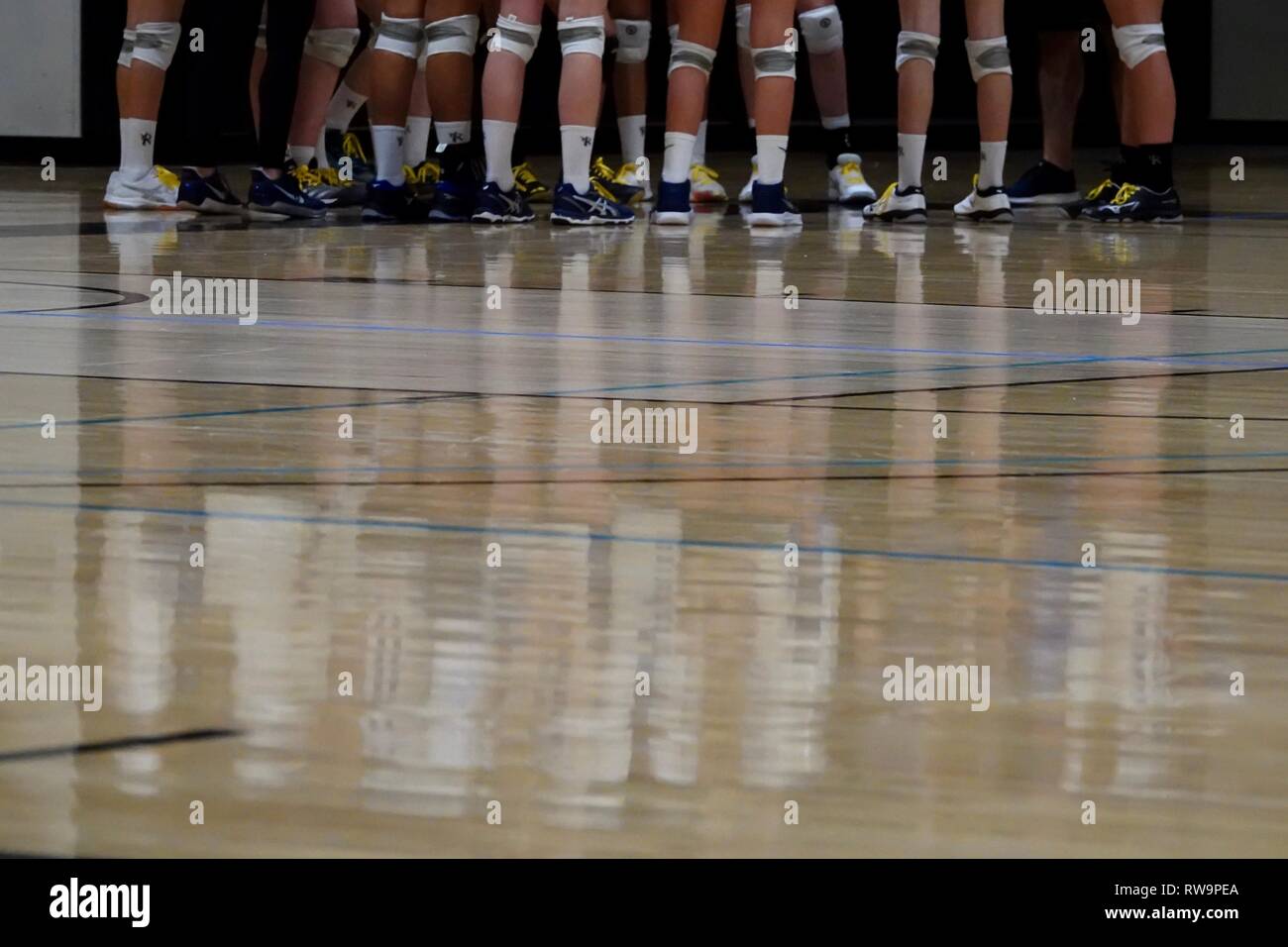 A reflection of girl a Volleyball team in a huddle reflected on the