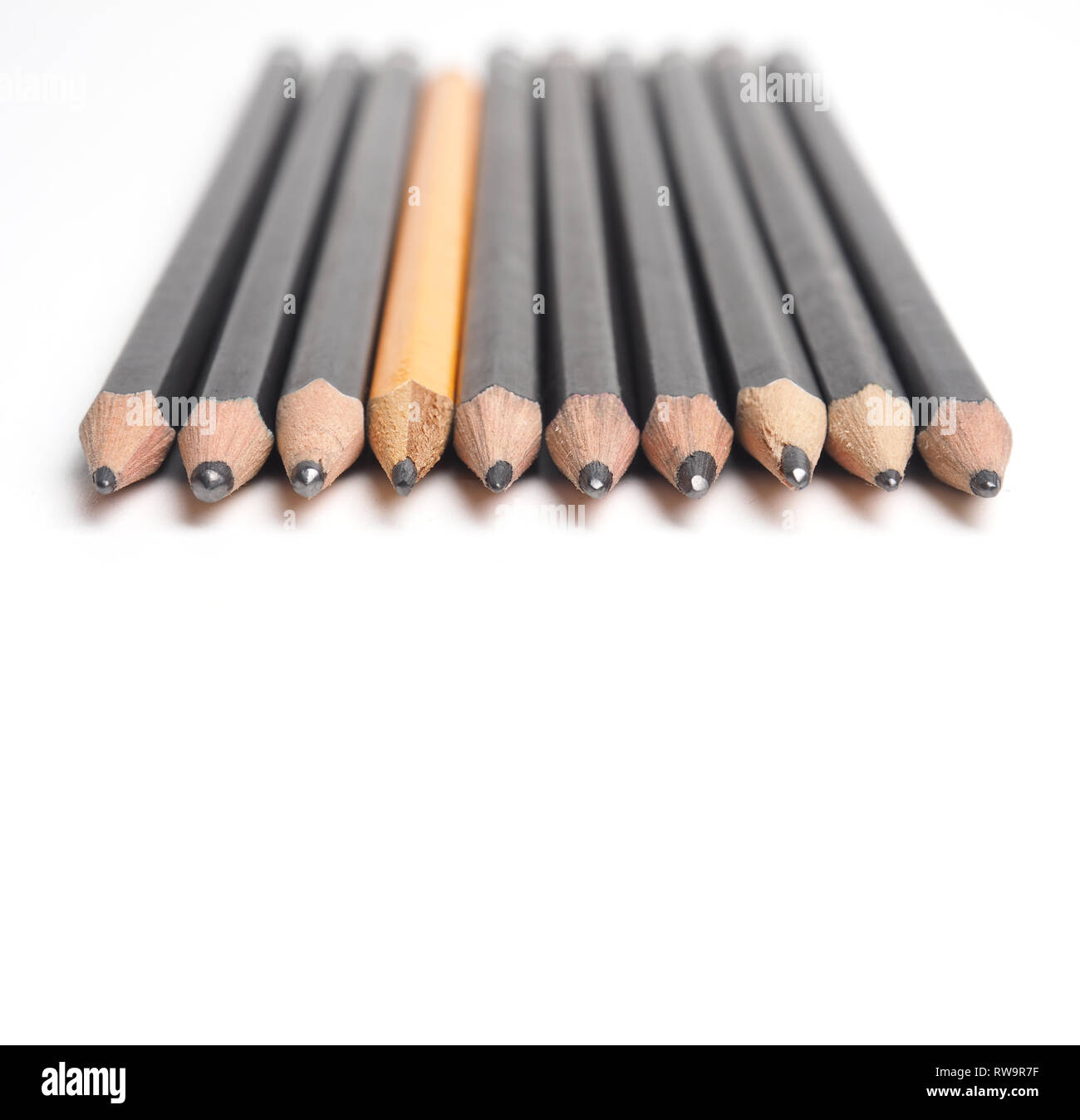 Set of Artist pencils in a row on a white table with space for text, selective focus on the foreground Stock Photo