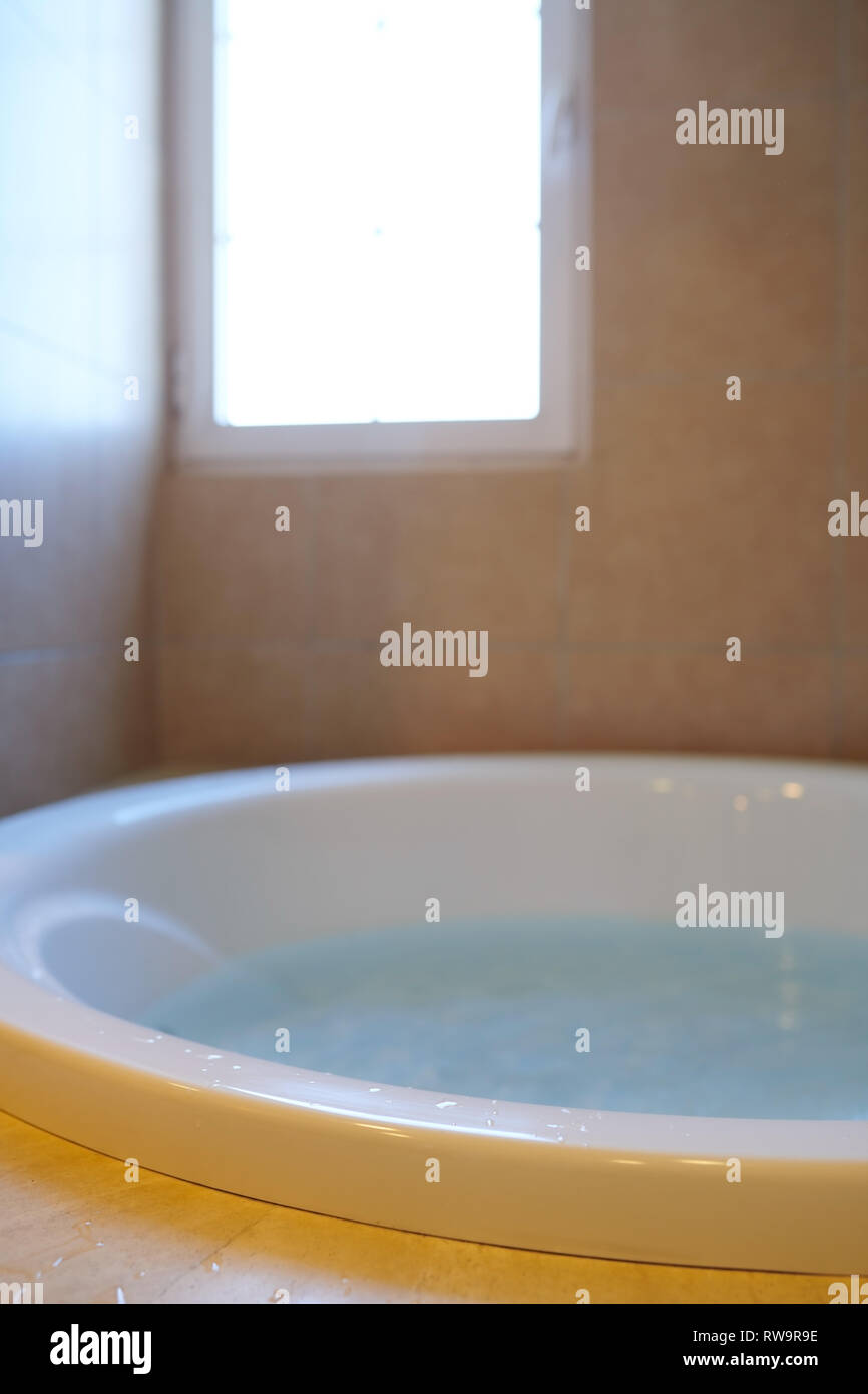 Modern bathroom with bathtube full of water Stock Photo