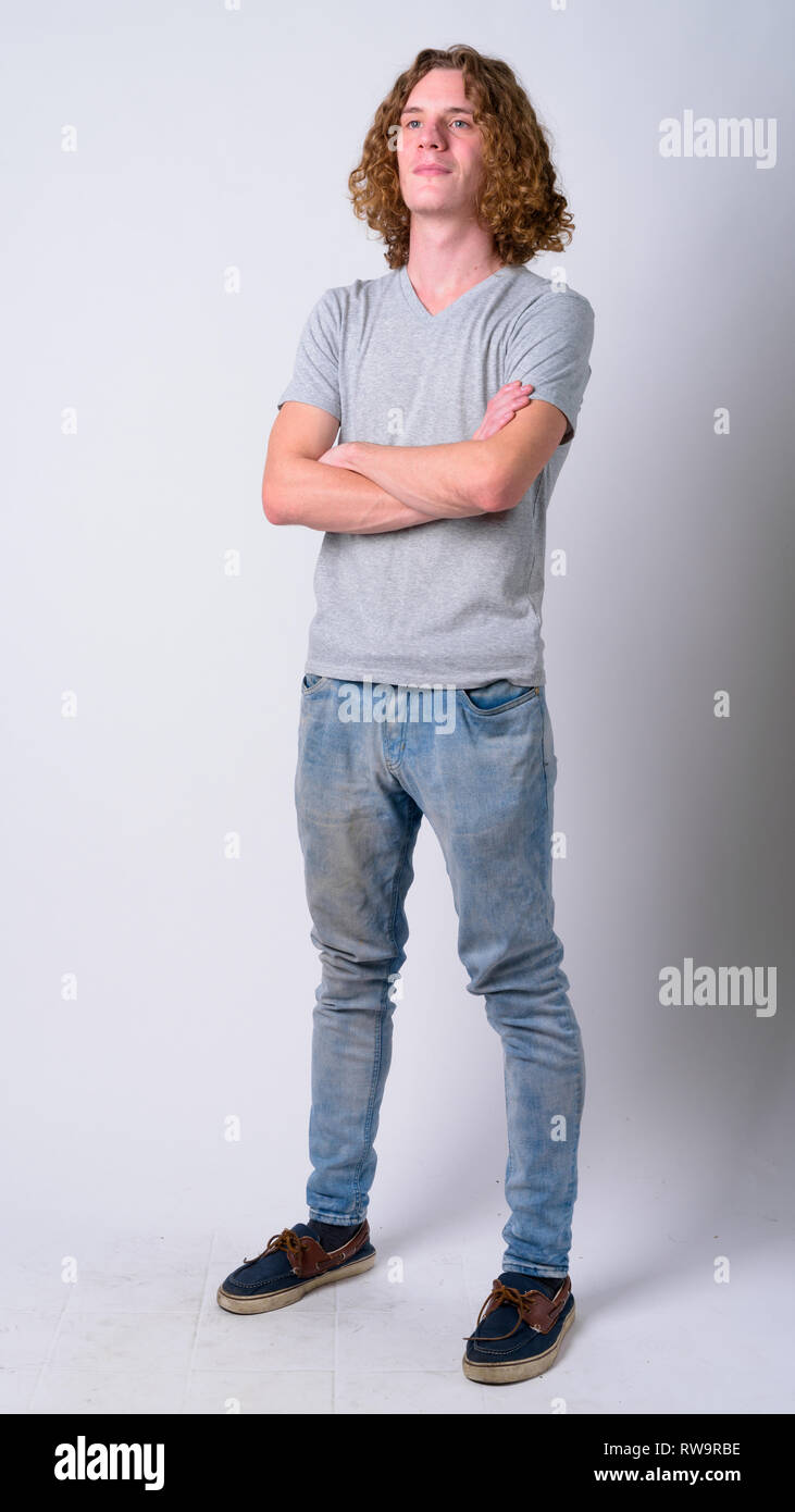 Full body shot of young handsome man thinking with arms crossed Stock ...