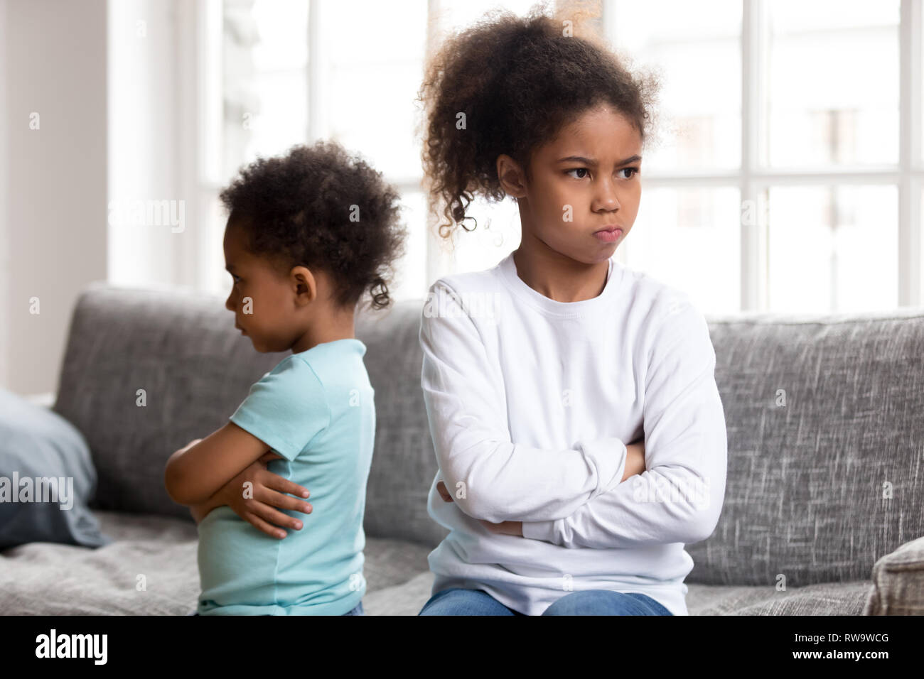 Stubborn little siblings avoid talking after fight Stock Photo