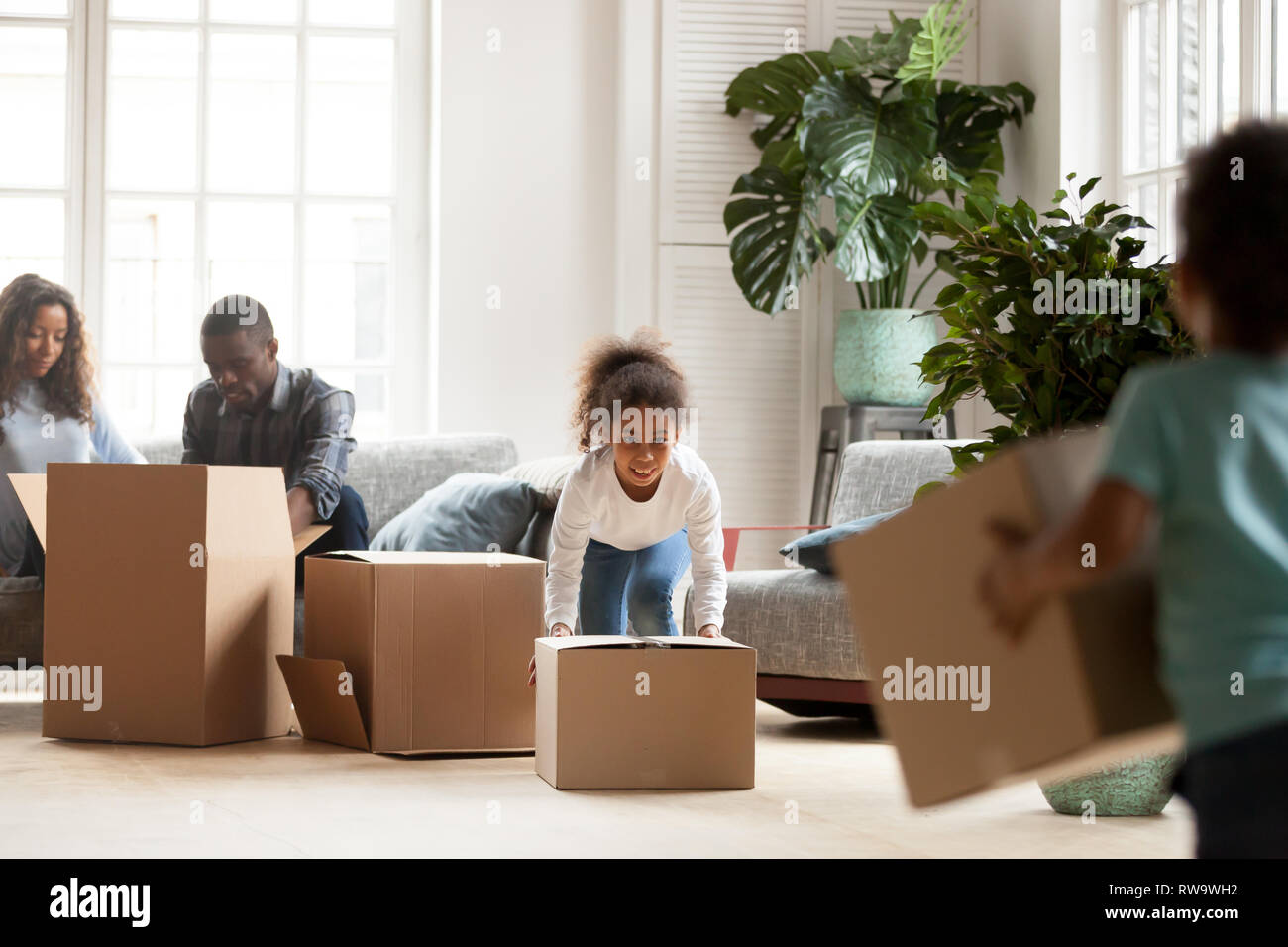 Little siblings play with boxes on moving day Stock Photo