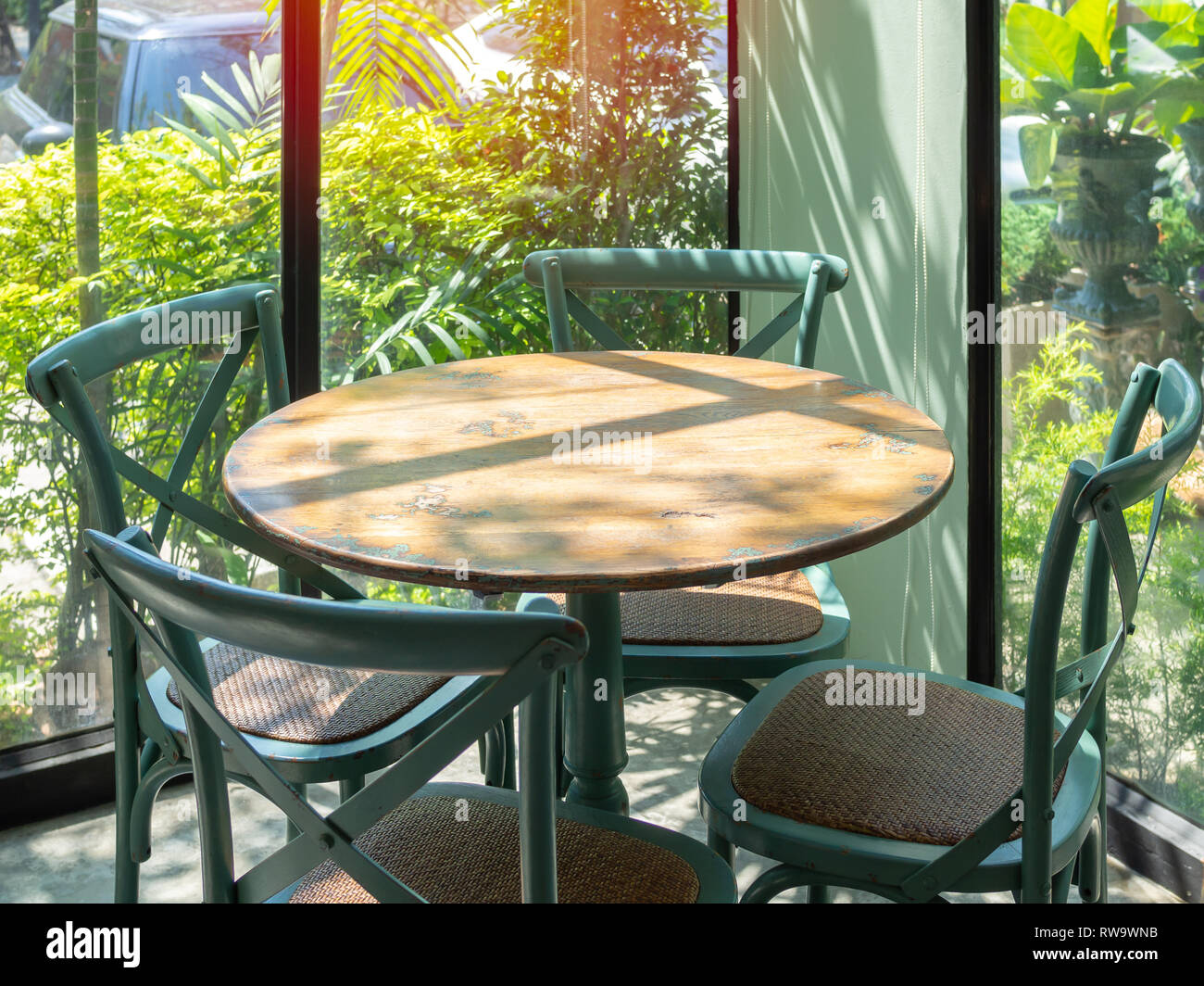 Vintage Wooden Table And Four Green Chairs In The Corner Of Restaurant With Window Glass Near The Garden Stock Photo Alamy