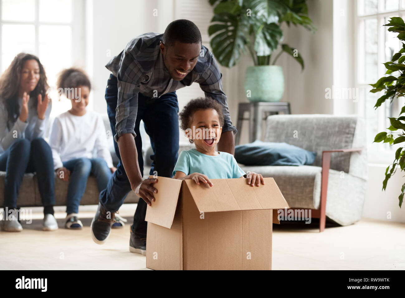 Happy black family play with kids moving to new home Stock Photo