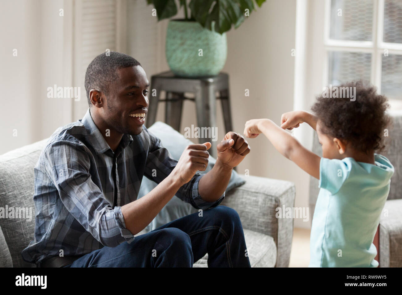 Happy black dad have fun playing educational game with toddler Stock Photo