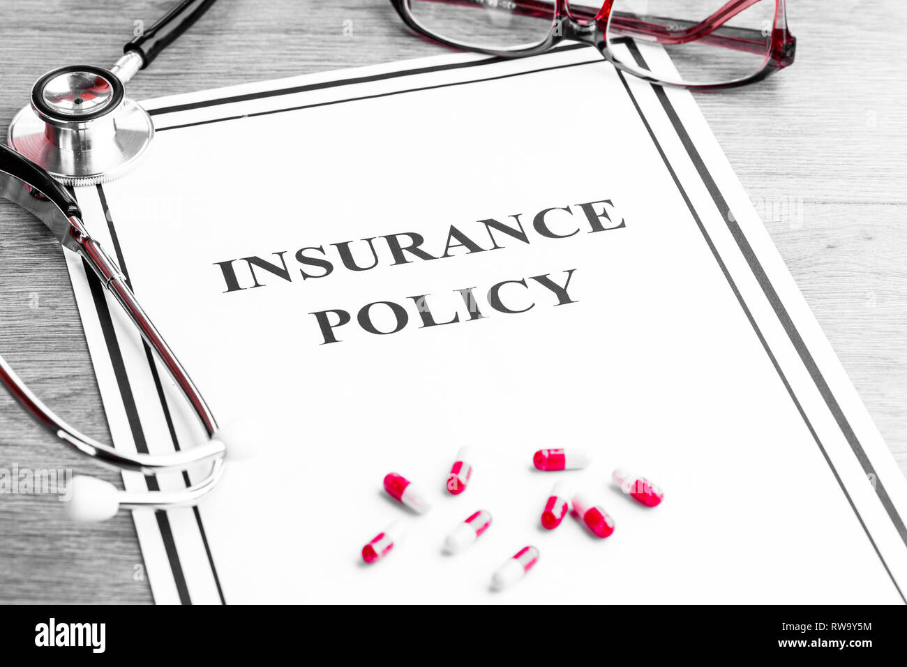 Health Insurance Policy. Stethoscope, Glasses, Dollars on Table Stock