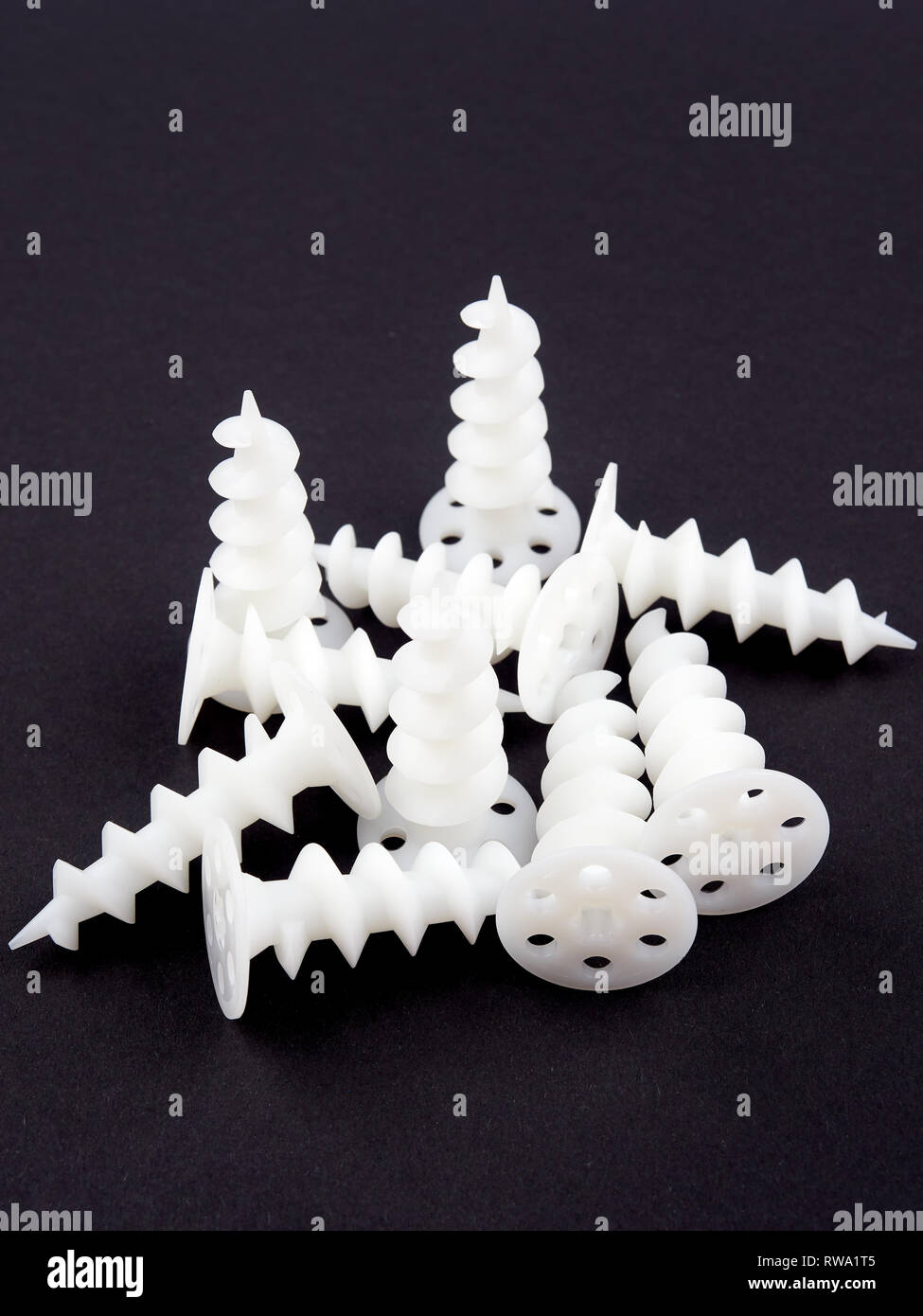 Special dowels for fixing light objects in styrofoam insulation, on black background Stock Photo