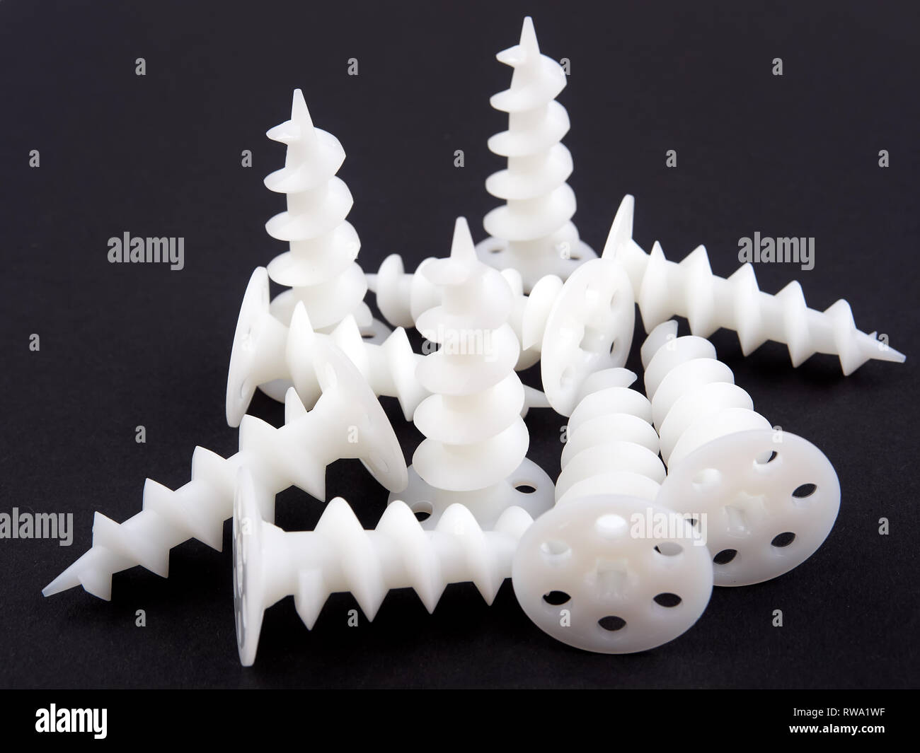 Special dowels for fixing light objects in styrofoam insulation, on black background Stock Photo