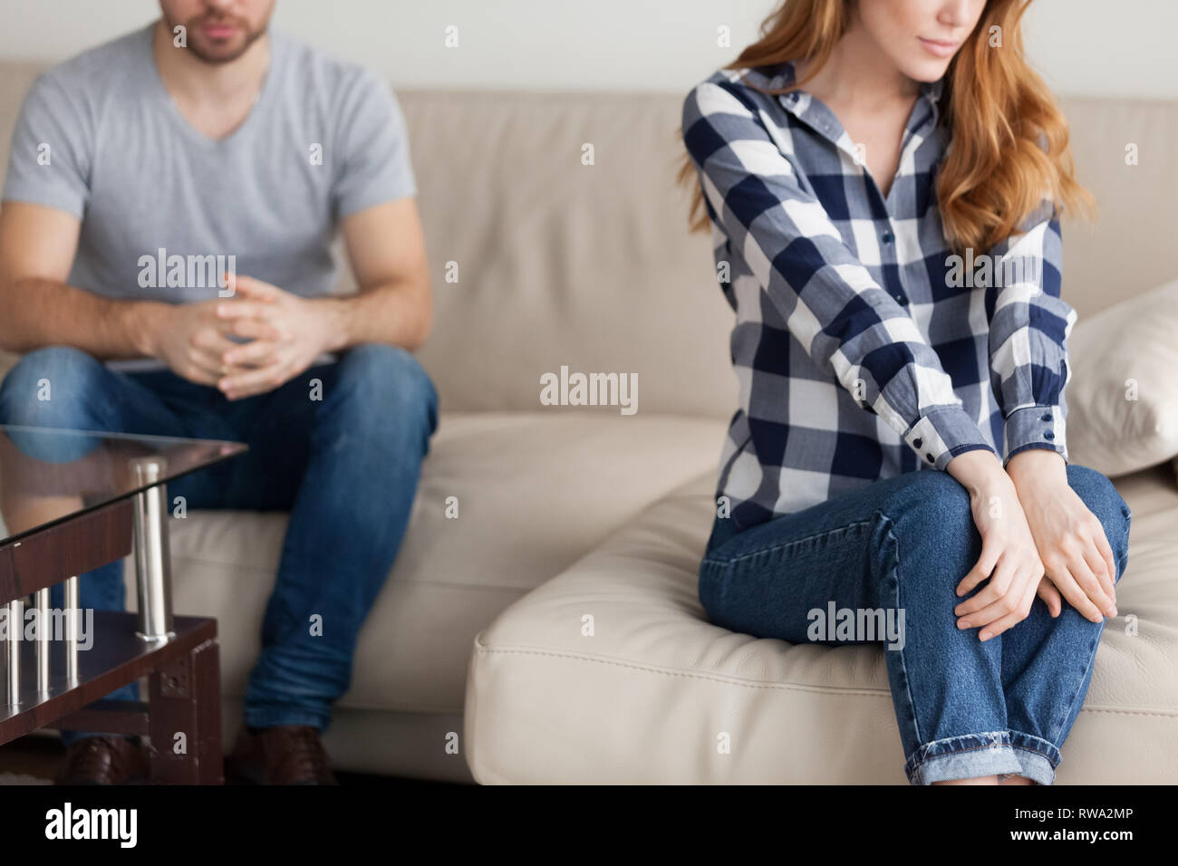 Closeup view of unhappy couple sitting on couch not talking Stock Photo