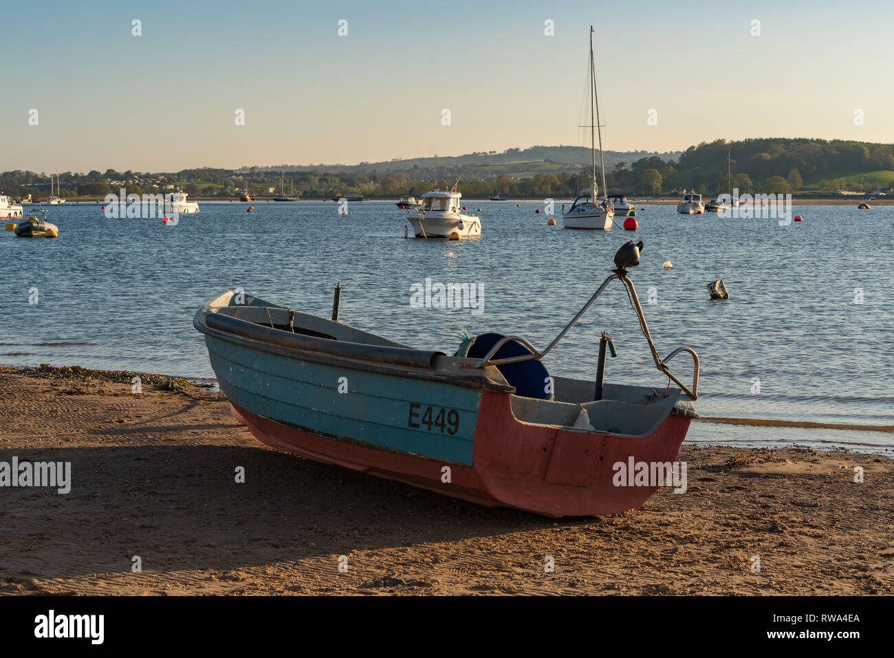 Emouth, Devon, England, UK - April 18, 2017: A Boat on the shore of the River Exe with other boats floating in the river in the background Stock Photo