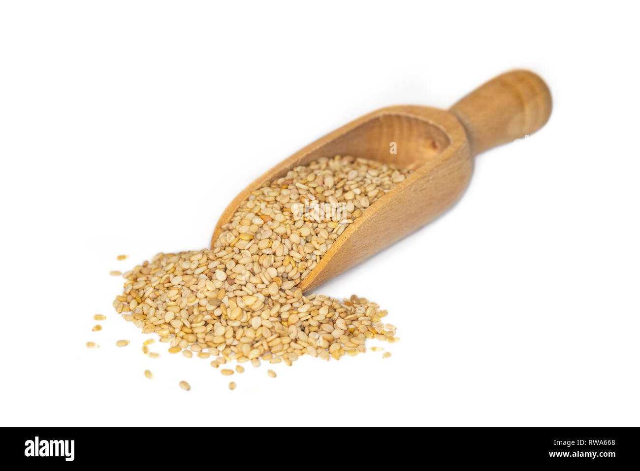 Closeup of sesame seeds, a plant based source of calcium and iron, presented on a small wooden scoop Stock Photo