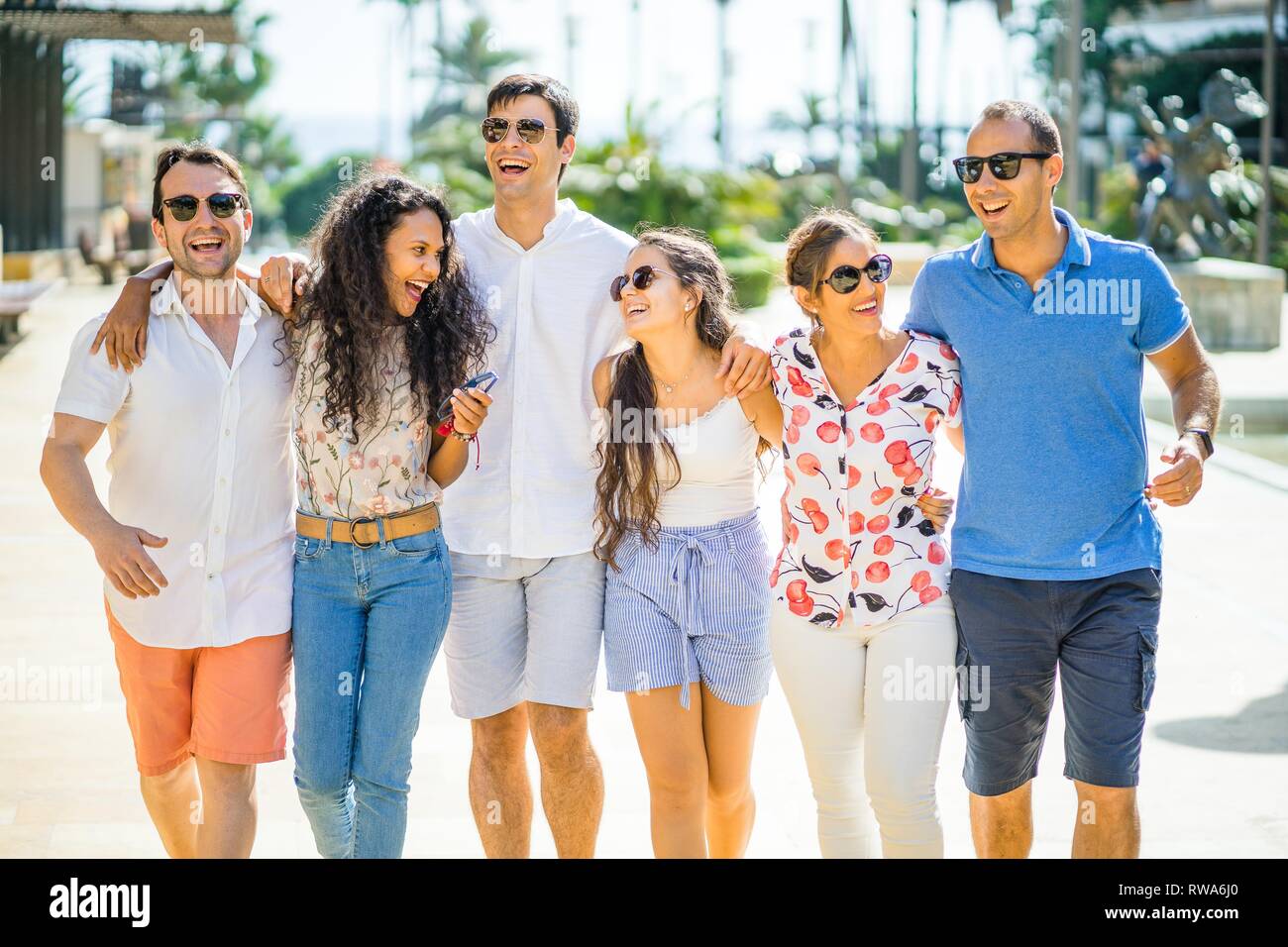 Six friends walking, taking, laughing and having fun during day time in urban setting, Portugal Stock Photo