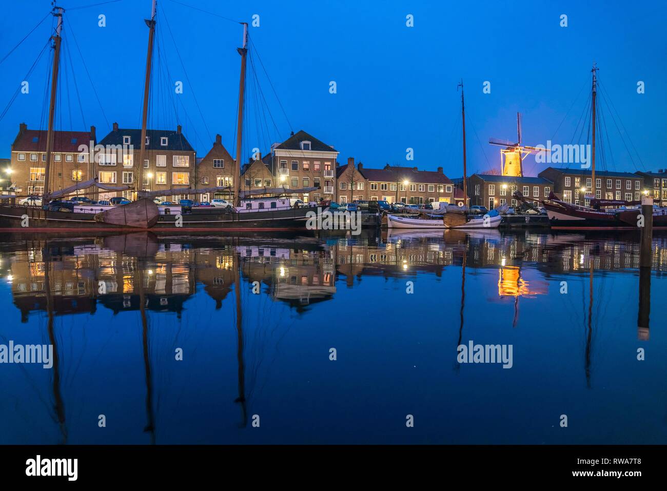 City view with harbour and windmill De Hoop at dusk, Hellevoetsluis, South Holland, Netherlands Stock Photo