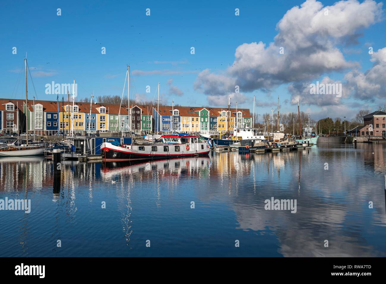 Boats in the harbour and colourful houses in Hellevoetsluis, South Holland, Netherlands Stock Photo