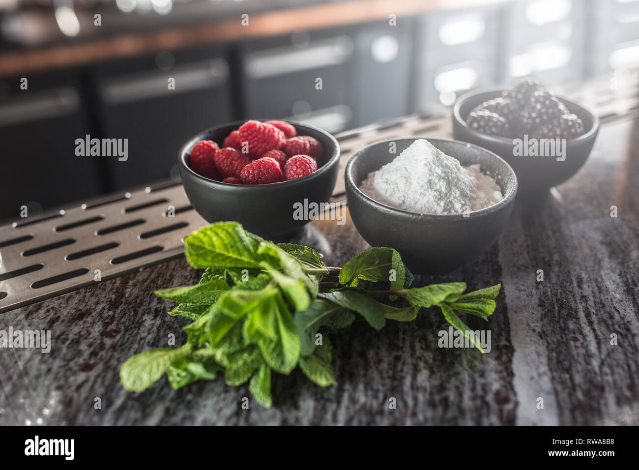 Blueberies raspberries blackberries sugar and mint at barcounter in night club or restaurant. Stock Photo