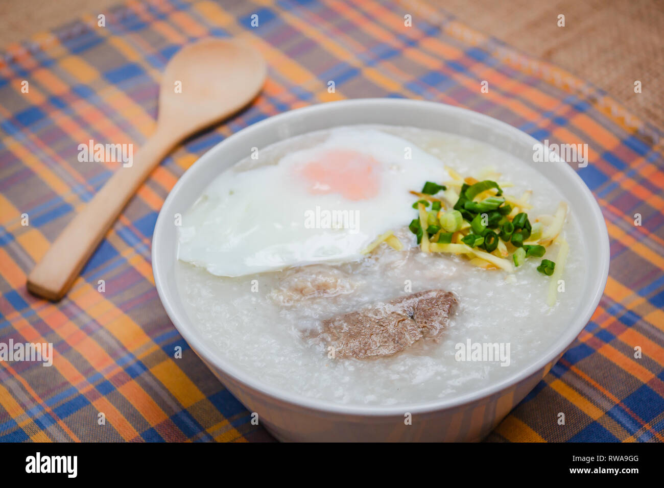 Rice porridge with soft boiled egg, ginger and chopped spring onion